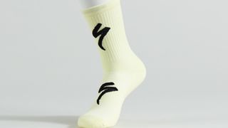 A pastel yellow sock with two black Specialized S logos
