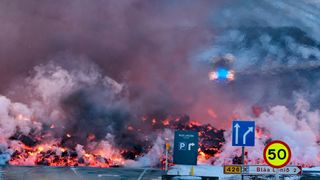 Molten lava is seen overflowing the road leading to the famous tourist destination "Blue Lagoon" near Grindavik, western Iceland on February 8, 2023.
