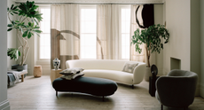 Neutral living room with bespoke geometric curtains, curved white sofa and warm minimalist aesthetic 