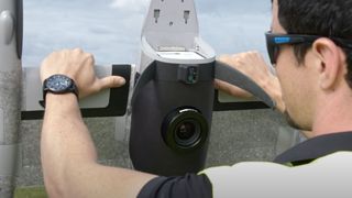 Man holding Trinity Pro drone looking at the Phase One P5 camera in the bottom