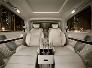 car with silver champagne flutes in the console between the two king-sized, fully reclining loungers in the passenger compartment