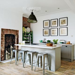 grey island with metal stools and framed prints