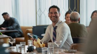 Mickey Haller smiles as he sits at a table in The Lincoln Lawyer season 3