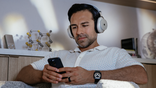 A man wears the MW75 Neuro headphone and looks at the app