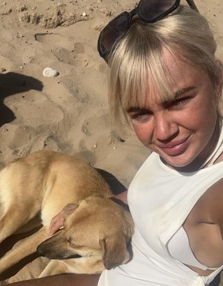 Saffron Dixon sitting with Moroccan street dog on beach