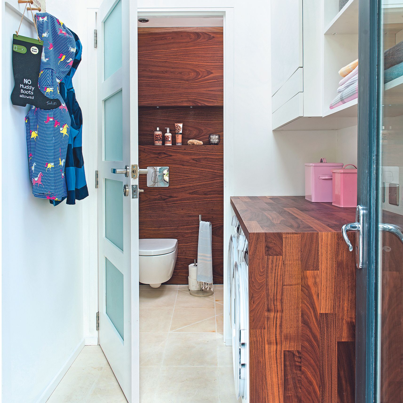 White laundry room leading onto small bathroom