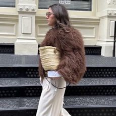 Jessica Habich Thomas wearing a fur coat with a straw bag