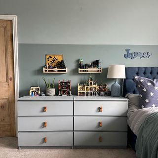 Kids bedroom with wooden shelves above double dresser