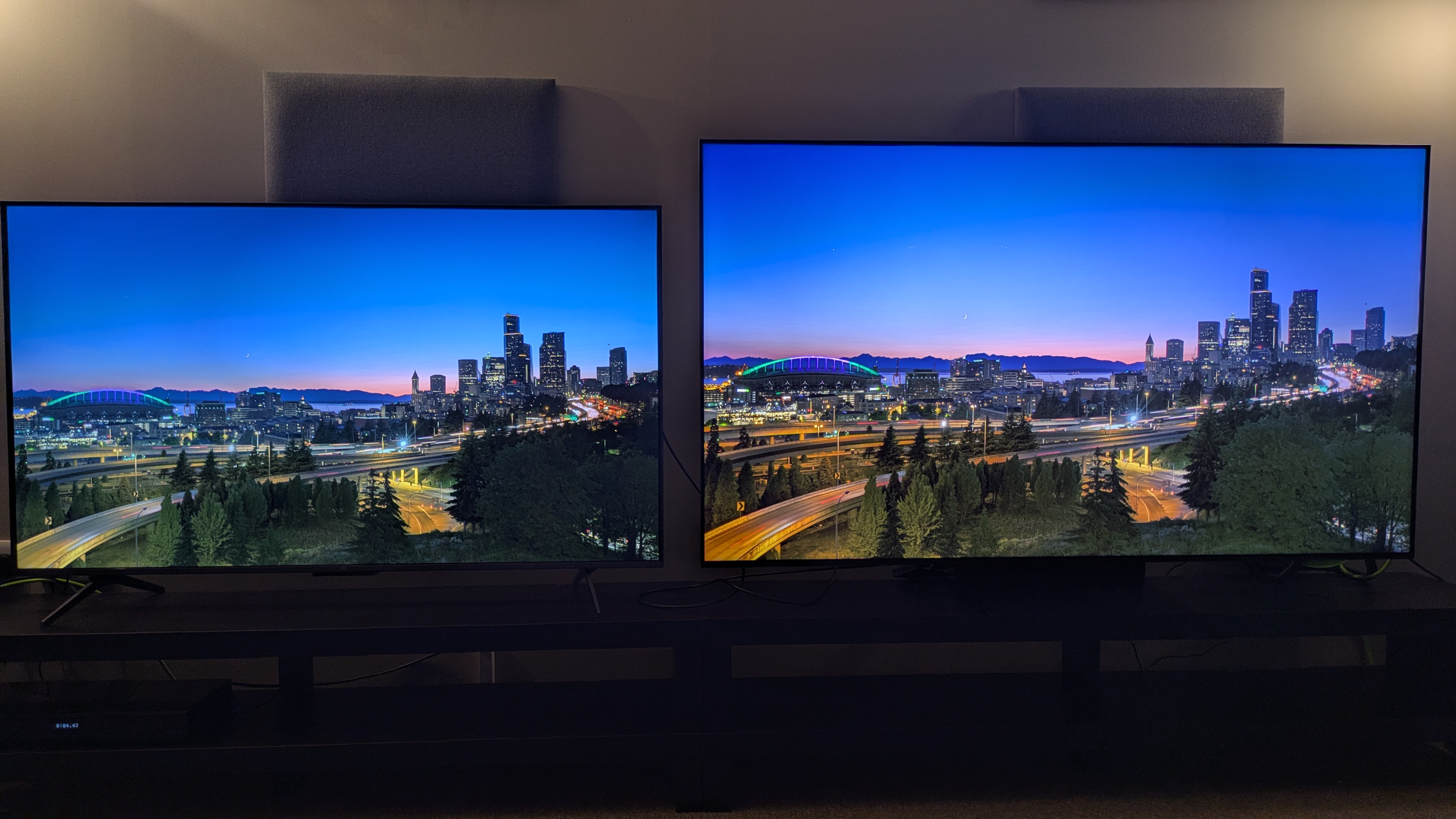 TCL C6K (left) and TCL C7K (right) showing city horizon at dusk on screen