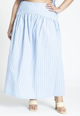 model wears blue and white striped maxi skirt with white heels