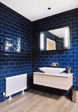 blue tiled bathroom with wooden sink