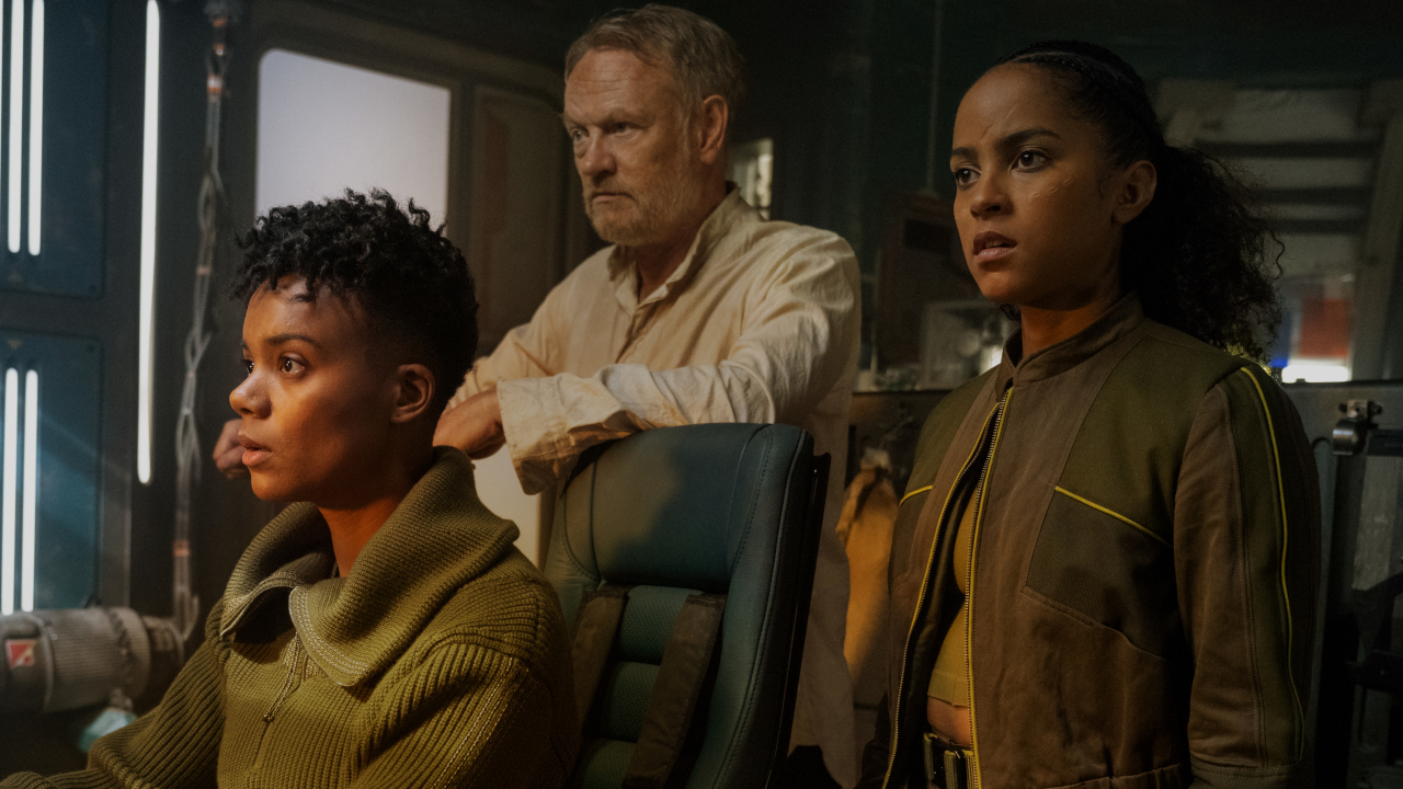 Leah Harvey, Jared Harris, and Lou Llobell looking ahead with concern in the cockpit in Foundation.