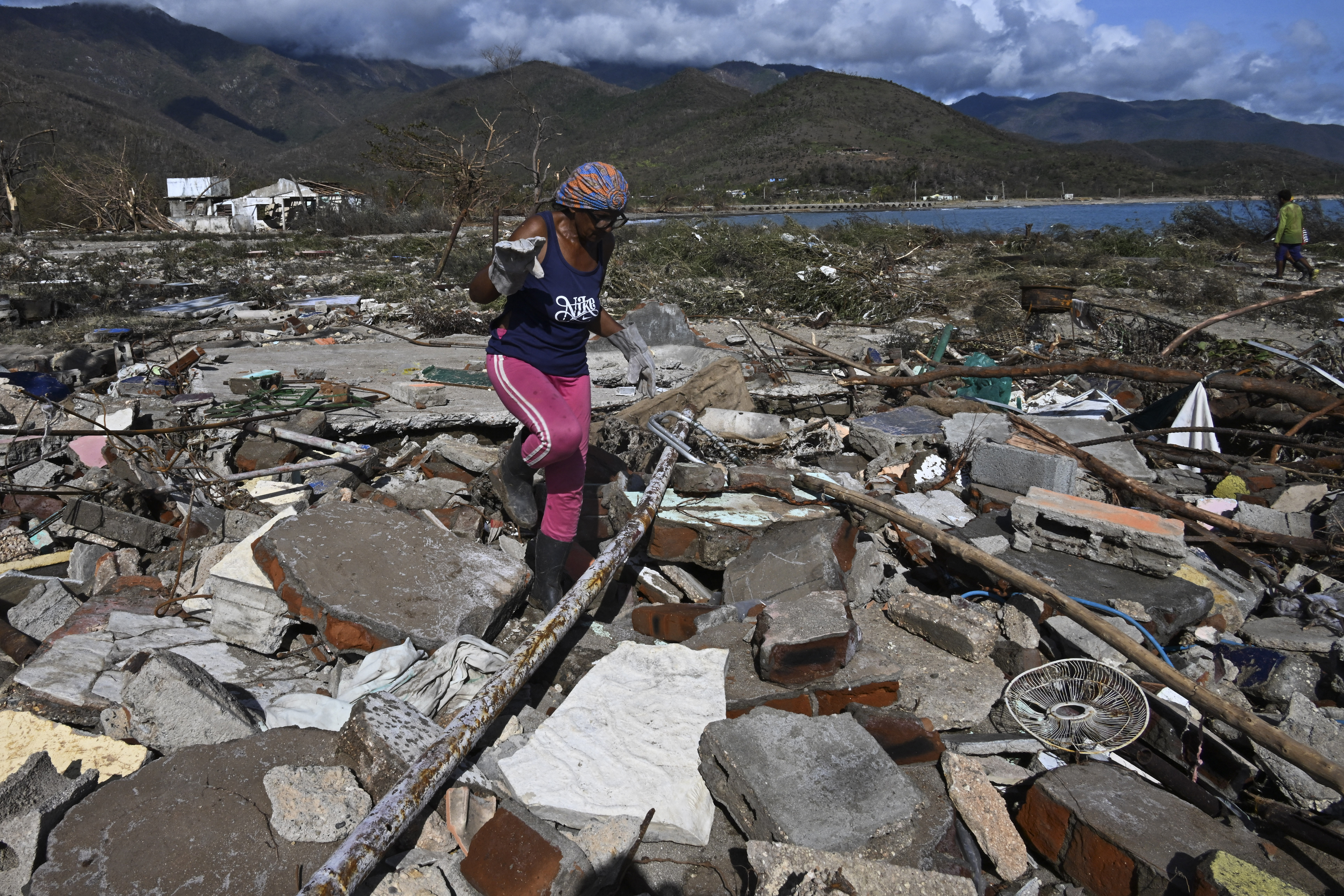 A woman walks amid debris of a damaged house after the passage of Hurricane Melissa in Boca de Dos Rios village, Santiago de Cuba province, Cuba on October 30, 2025