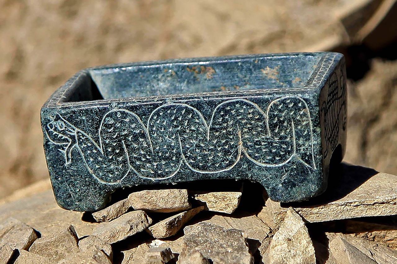a close-up of a blue box with a snake engraved on its side