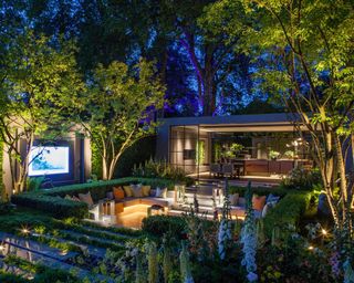 An example of how to install garden lighting showing a garden seating area with clever lighting and a cinema screen