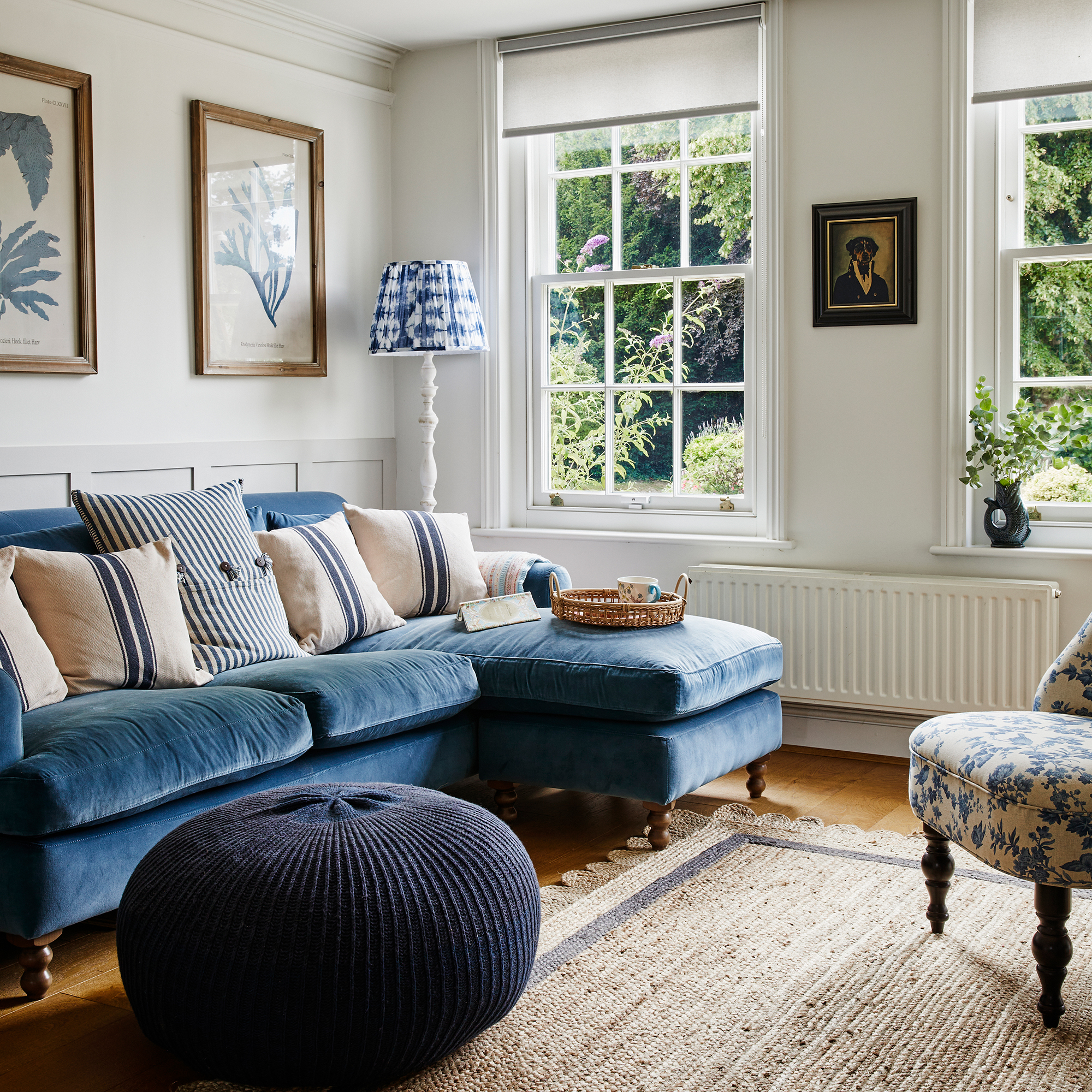 coastal style living room in georgian house with blue sofa and pouffe