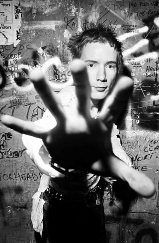 Johnny rotten with his hand outstretched to camera