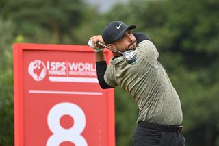 Alex Levy hits a fairway wood and watches its flight