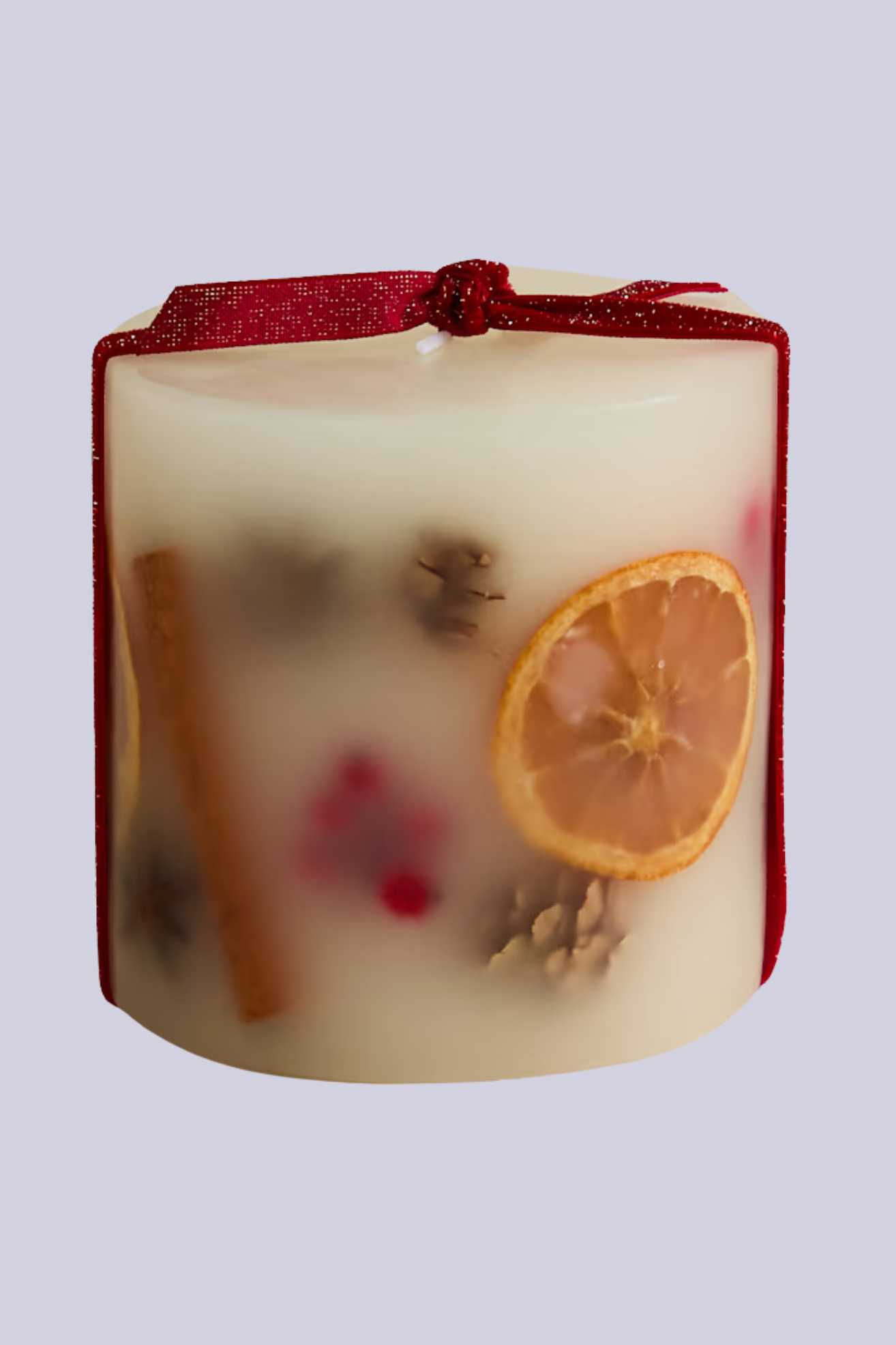 An inclusion candle with pinecones, cinnamon, and orange slices
