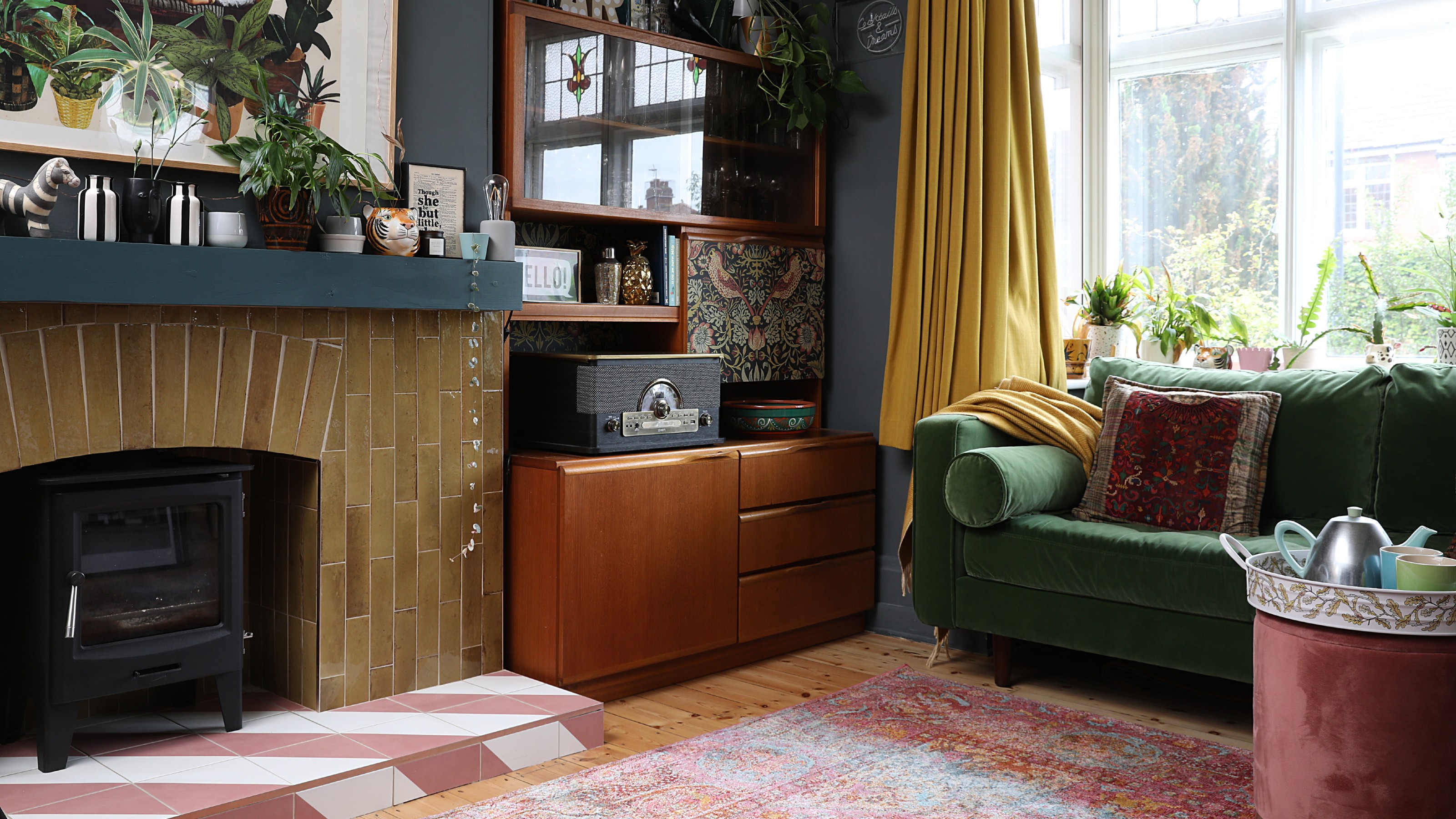 A teal-painted living room with a tiled fireplace in mustard yellow 