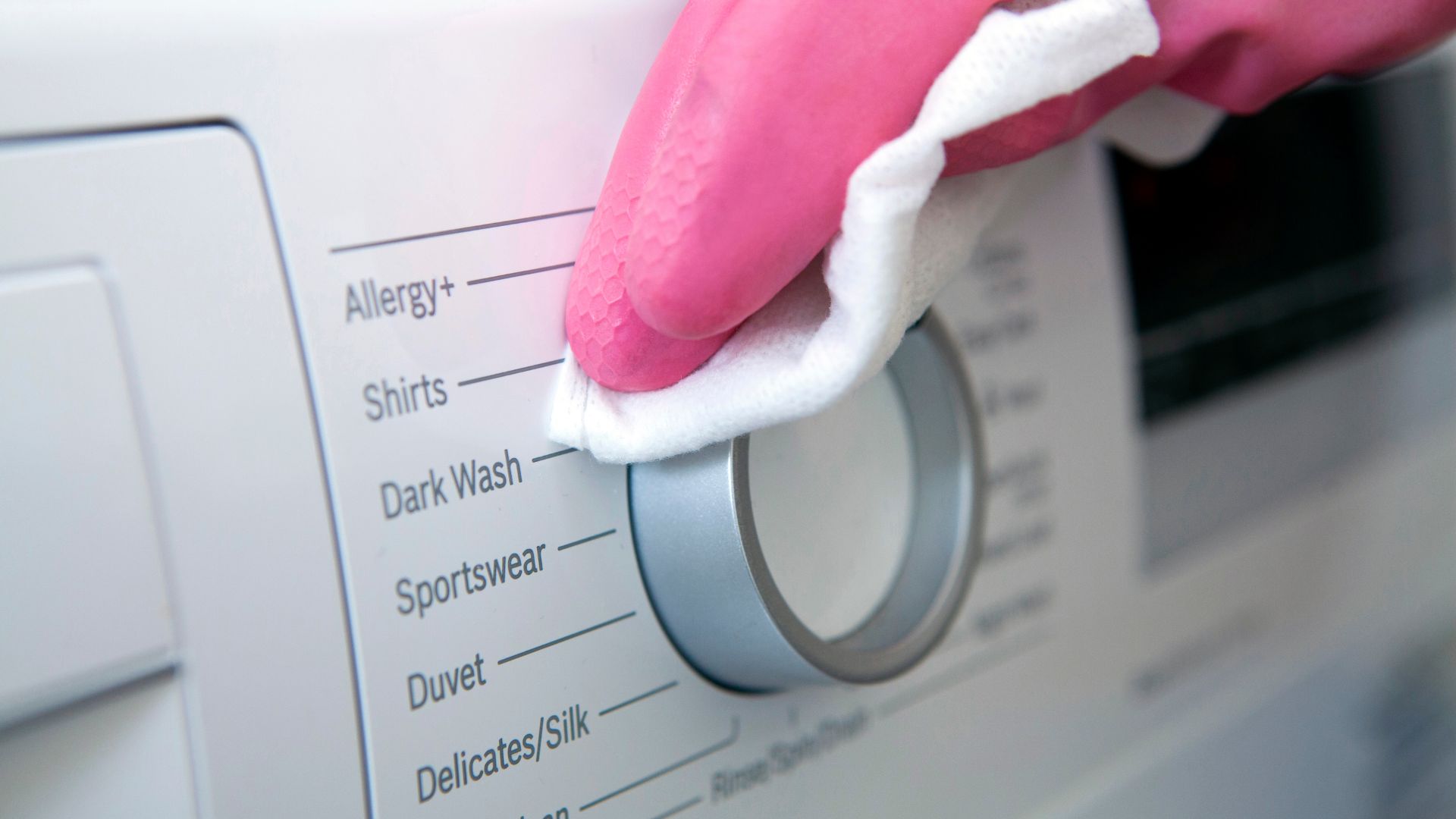 picture of person wiping down the outside of a washing machine