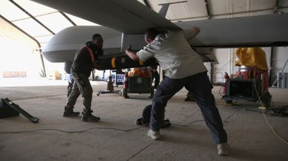A Hellfire missile is loaded onto a US Air Force unmanned aerial vehicle (UAV) in 2016 