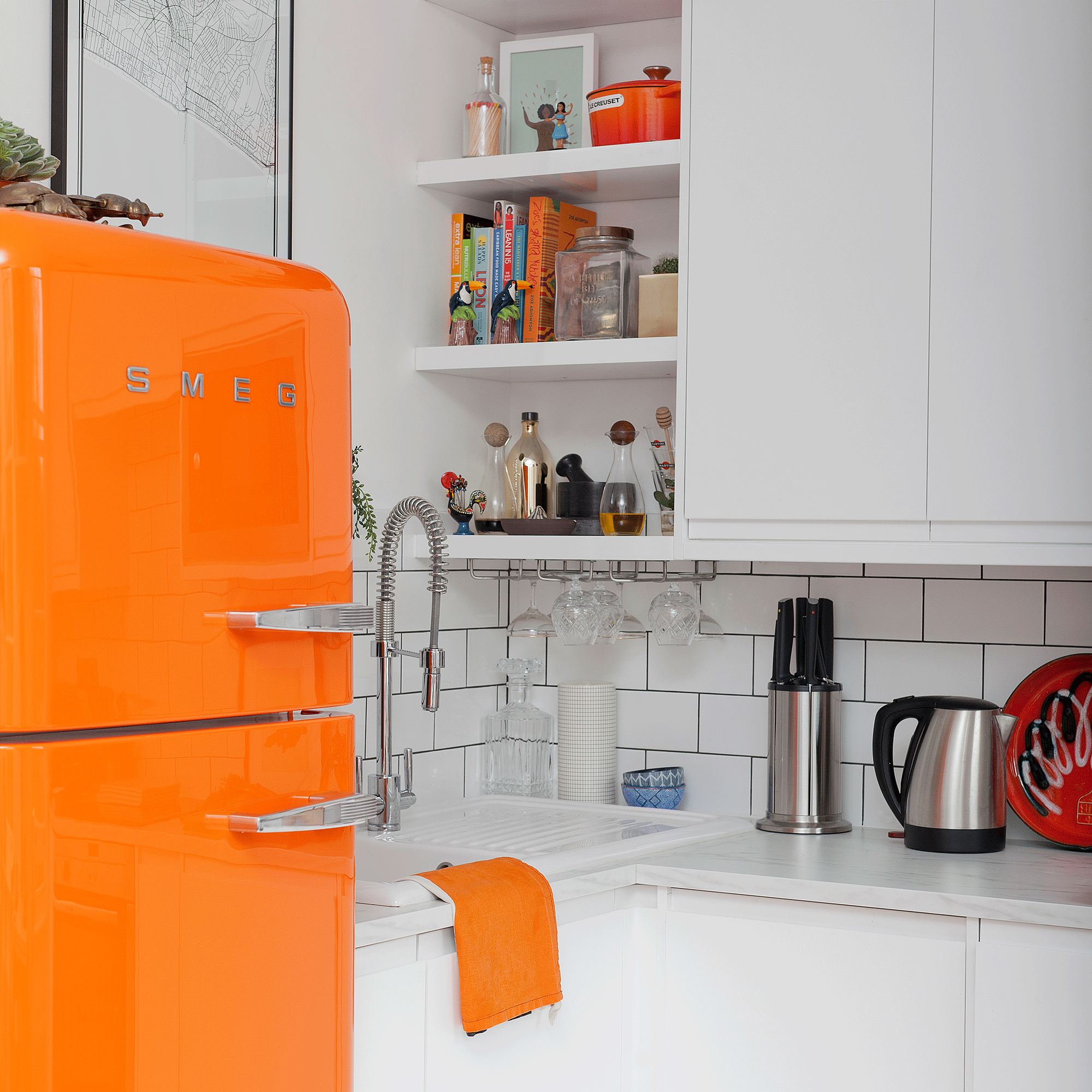 Orange fridge in white kitchen with tiles