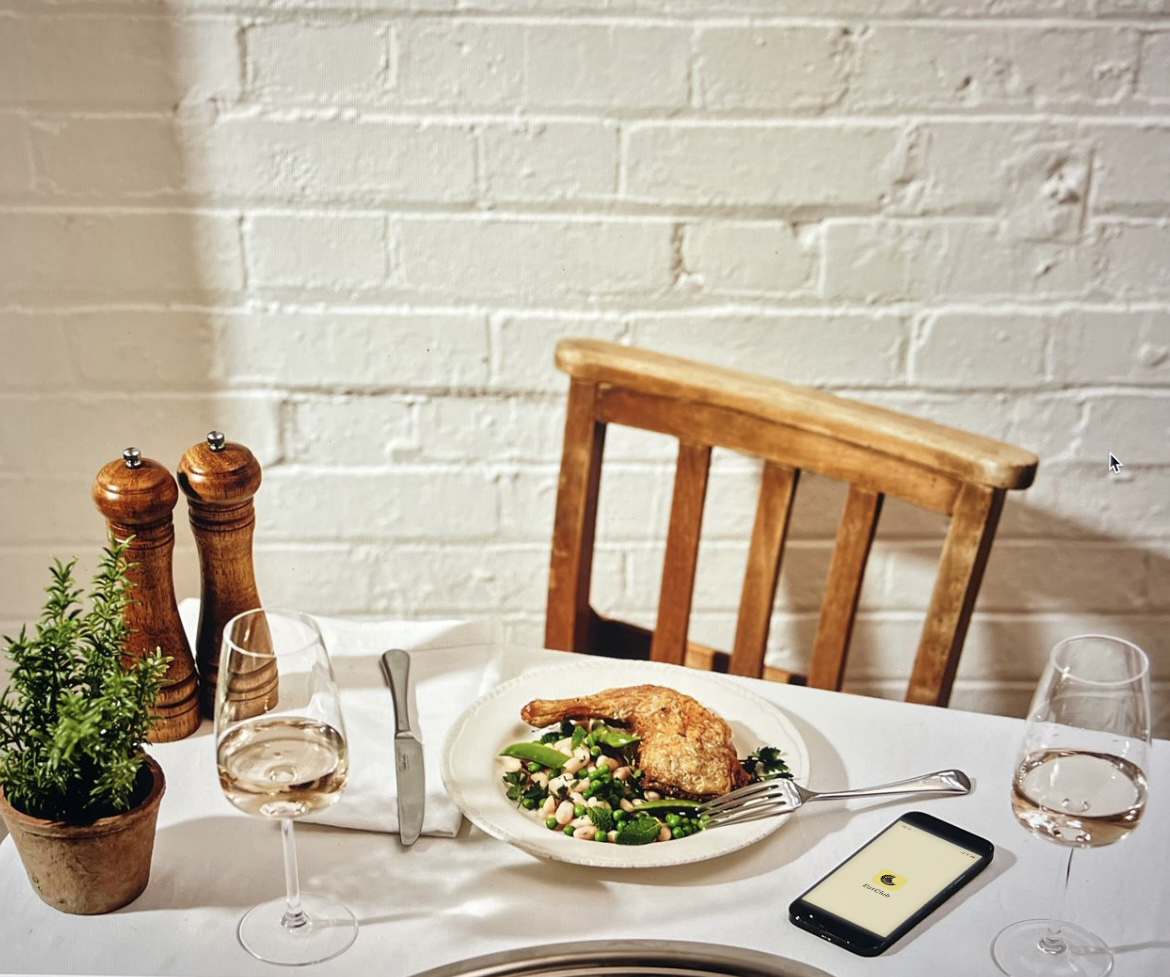 an image of a table of food with the eat club app open on a phone on the table