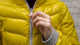A woman zips up her jacket 