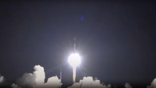 a black and white rocket launches into a night sky
