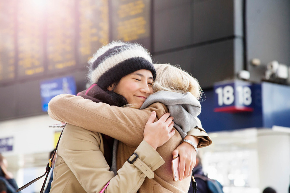 Two women are embracing at the train station