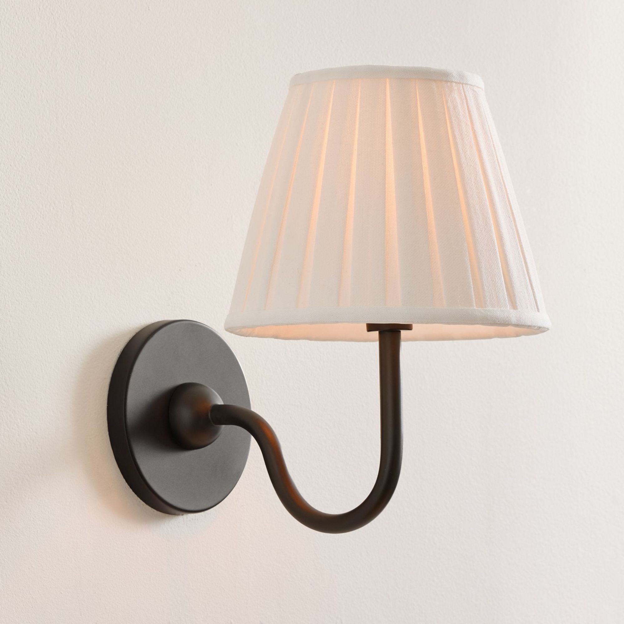 Bronze sconce with white pleated shade