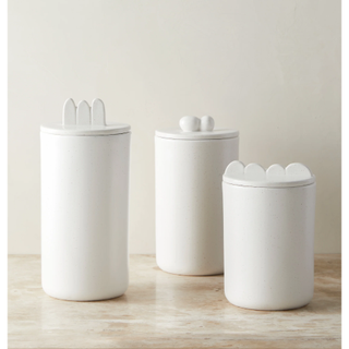 three white canisters with wavy handles