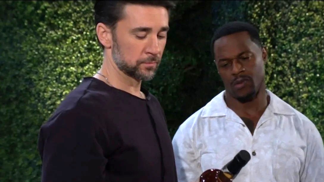 Billy Flynn as Cane holding a bottle of wine with Jermaine Rivers as Damian standing nearby in The Young and the Restless
