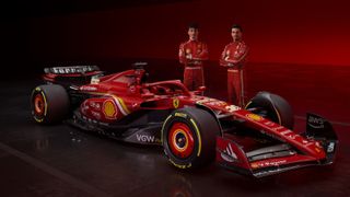 Charles Leclerc and Carlos Sainz stand behind the Ferrari SF24 F1 car at the official launch ahead of F1 Testing 2024 in Bahrain.