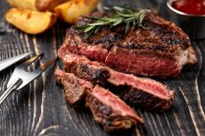 Juicy steak medium rare beef with spices on wooden board on table