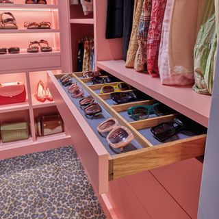 pink walk-in wardrobe with drawer for sunglasses and clothes storage