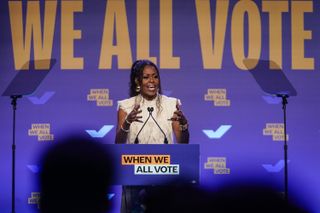 Former first lady Michelle Obama speaks at a When We All Vote rally on October 29, 2024 in College Park, Georgia. With one week until Election Day, top surrogates for Kamala Harris including the Obamas continue to campaign on her behalf in battleground states. she wore a white blouse and jeans