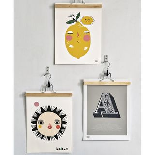 white wall with cloth hanger and prints