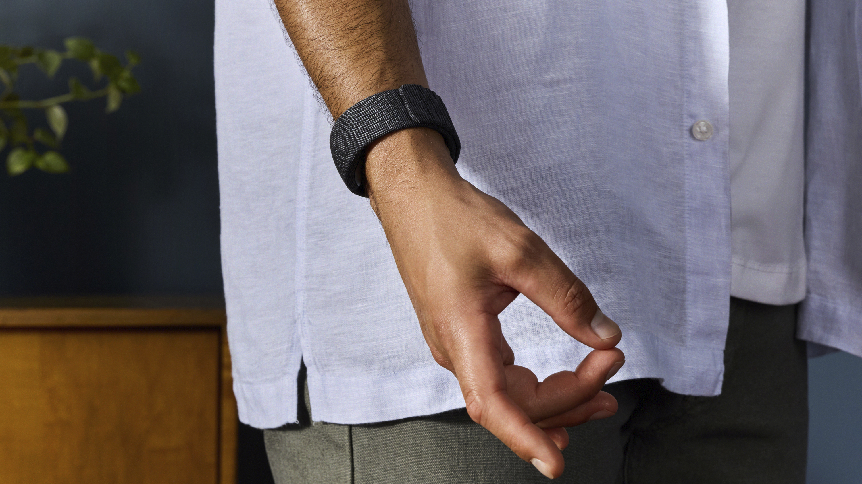 Press photo of Meta's Orion EMG wristband, with the wearer making a pinching gesture.