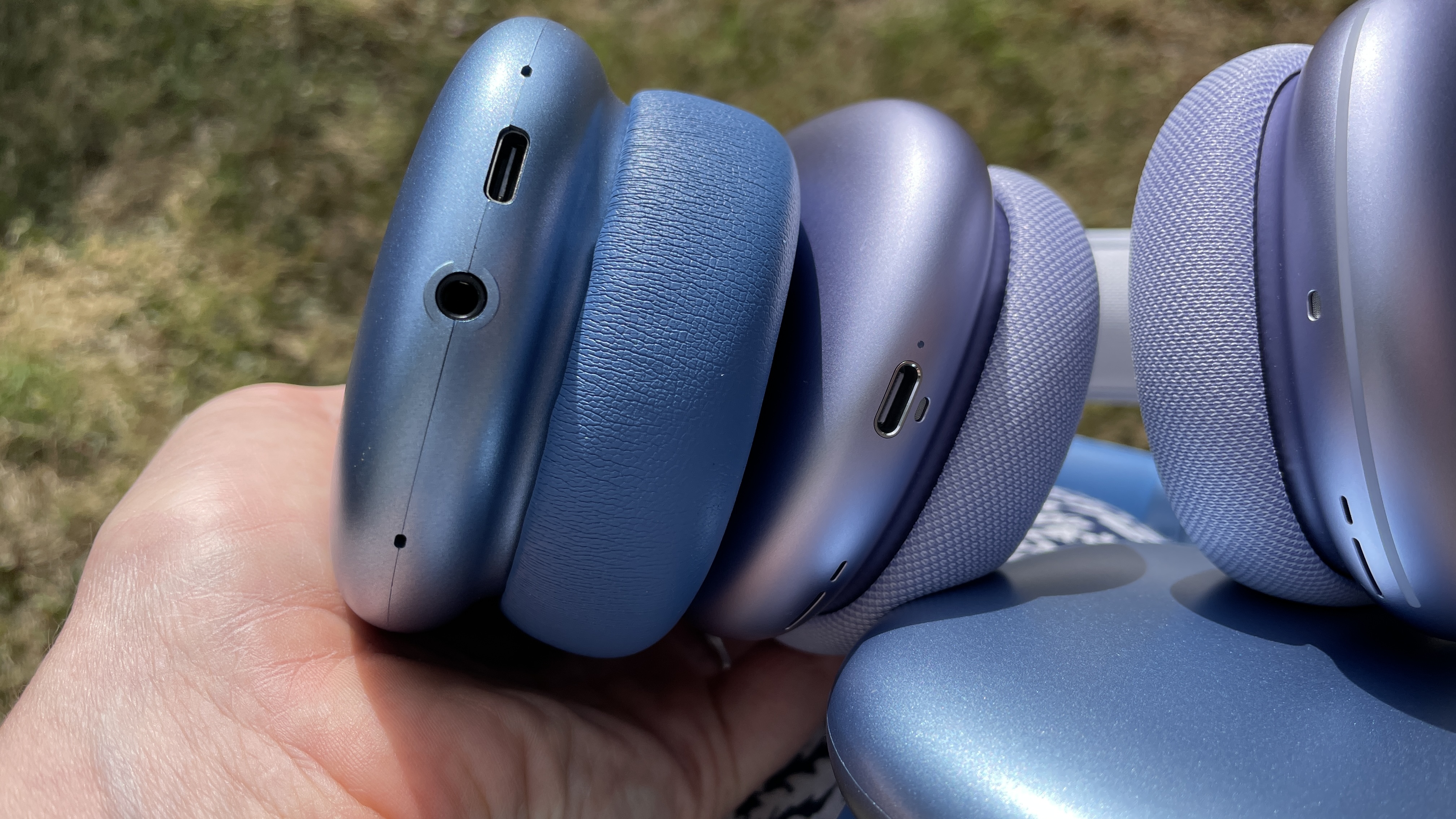 Wentronic YO1 (AirPods Max dupe) headphones in blue with AirPods Max nearby to compare and contrast their looks, outside on a sunny day
