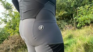 Close up of rear of man wearing cycling bib shorts with hedgerow behind