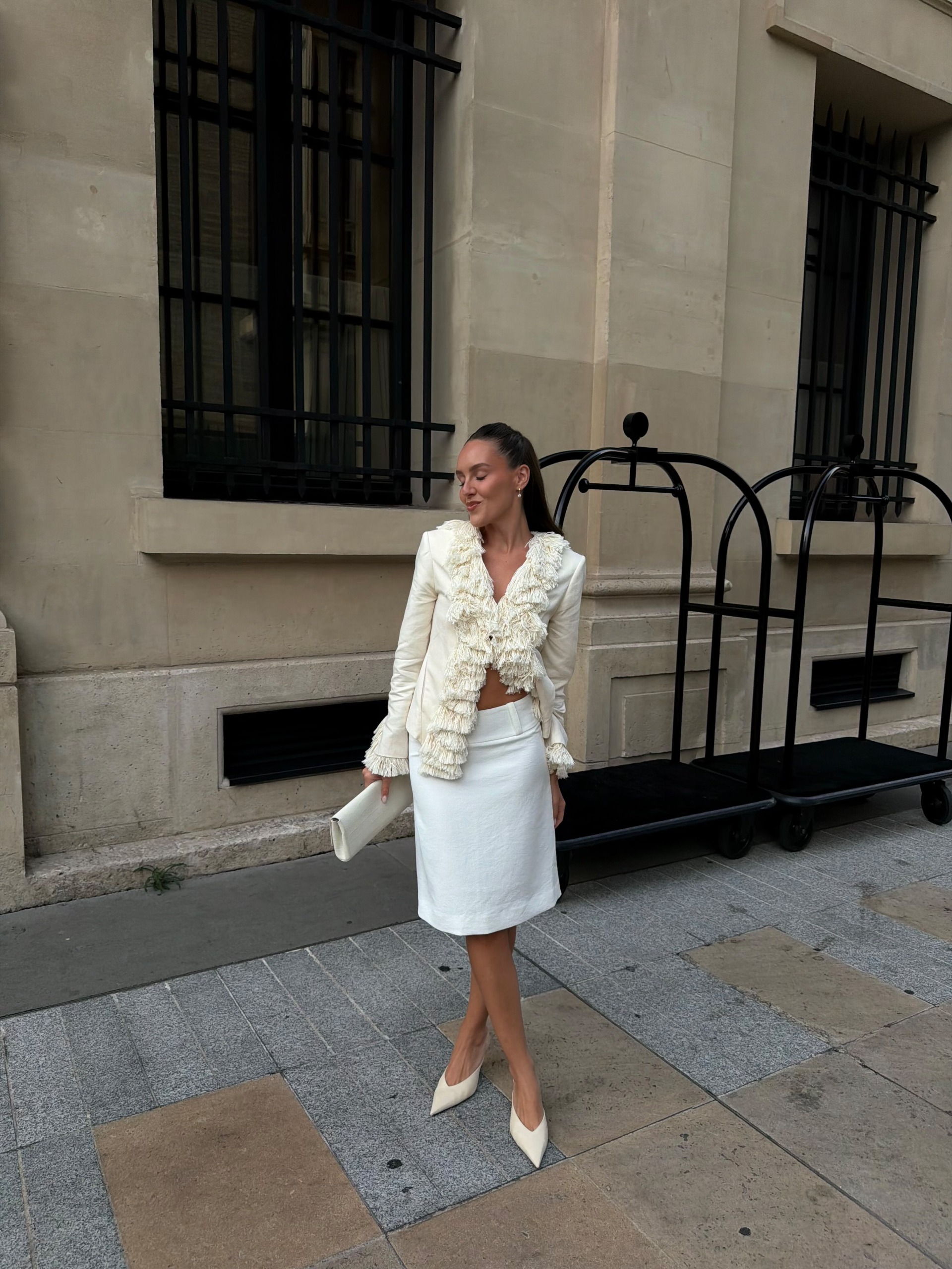 An image of @emmaleger wearing a tasselled jacket with a pencil skirt.