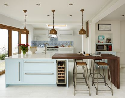 A duck egg blue kitchen island with feature lighting from Harvey Jones