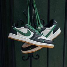 Two Nike sneakers hanging by their green laces 