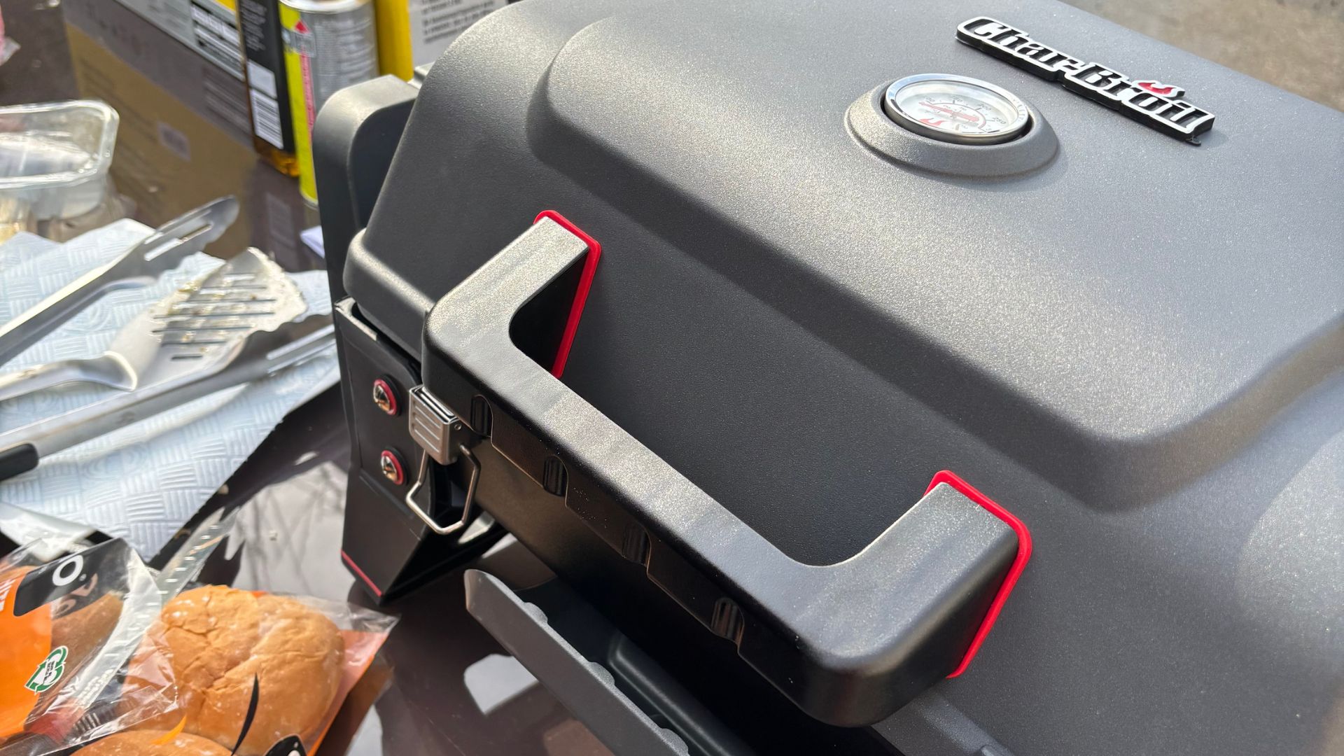 The Char-Broil Grill2Go X200 set up in a back garden during testing, positioned on a patio in warm, sunny weather, ready for outdoor cooking.
