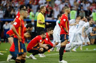 Spain players look dejected as Russia celebrate their win on penalties at the 2018 World Cup.