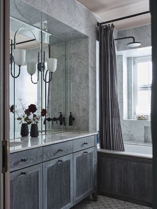 Bathroom tiled with marble tiles and fitted with a grey wood vanity unit