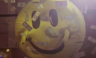 Person in a bright yellow smiley face costume with bank notes