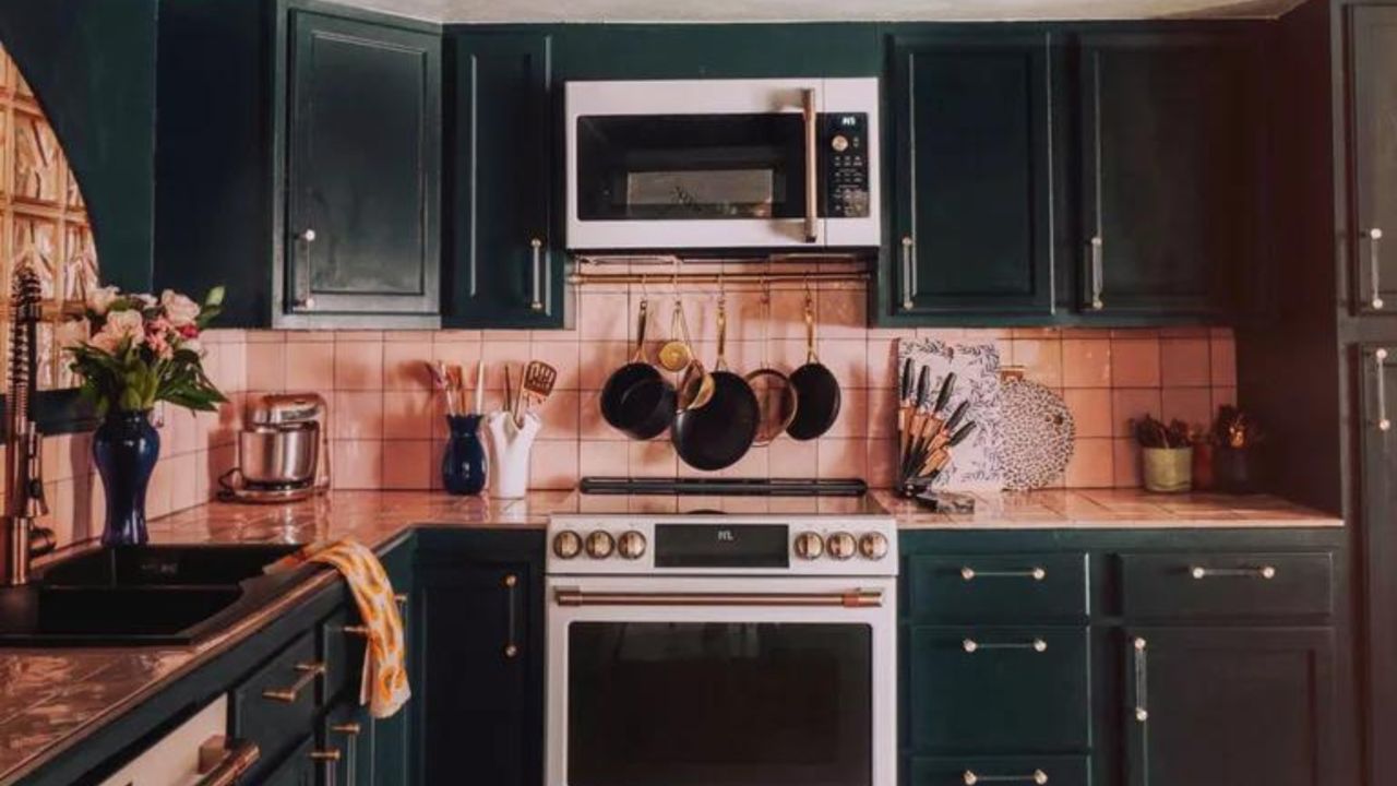 Dark green kitchen cabinets with blush pink walls